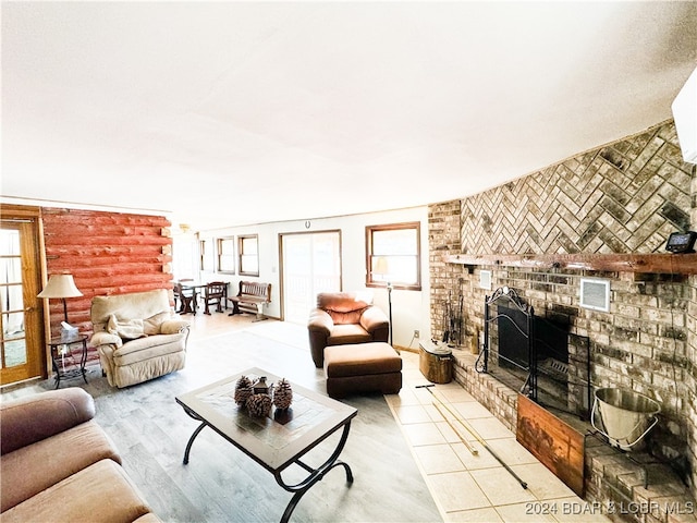 living room with a wealth of natural light, a brick fireplace, and visible vents