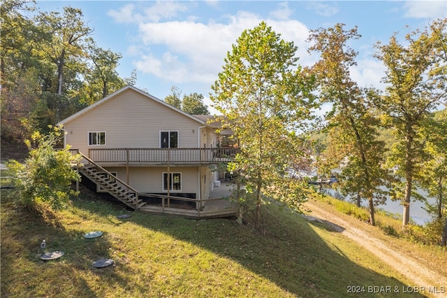 back of house featuring a lawn and a wooden deck