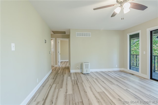 empty room with ceiling fan and light hardwood / wood-style flooring