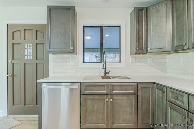 kitchen featuring light hardwood / wood-style flooring, decorative backsplash, stainless steel dishwasher, and sink