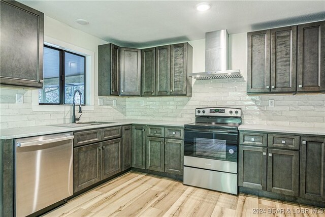 641 Porter Mill Springs Rd, Sunrise Beach, MO 65079 - kitchen featuring wall chimney range hood, appliances with stainless steel finishes, a sink, and light countertops