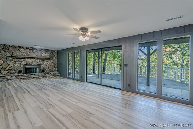 unfurnished living room with a fireplace, light wood-type flooring, and ceiling fan