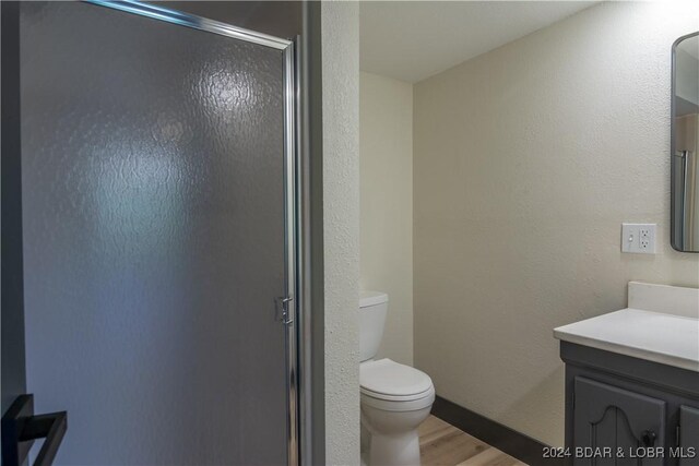 641 Porter Mill Springs Rd, Sunrise Beach, MO 65079 - bathroom with vanity, toilet, wood finished floors, and a stall shower