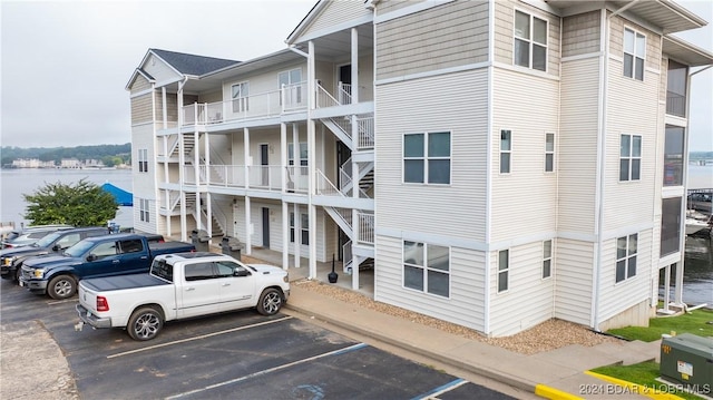 4935 Robins Cir Unit 111, Osage Beach, MO 65065 - view of property featuring uncovered parking, a water view, and stairs