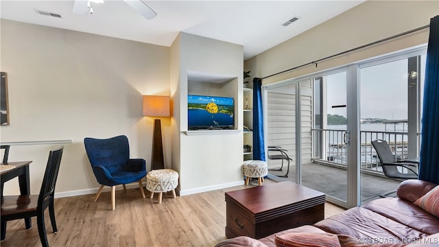 living room featuring light wood-type flooring and ceiling fan