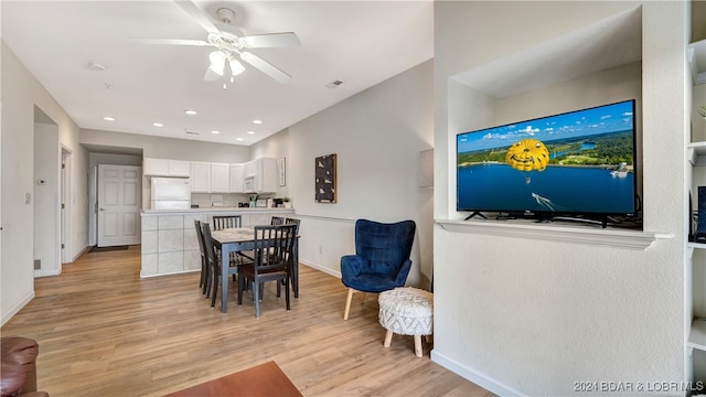 dining area with light hardwood / wood-style floors and ceiling fan