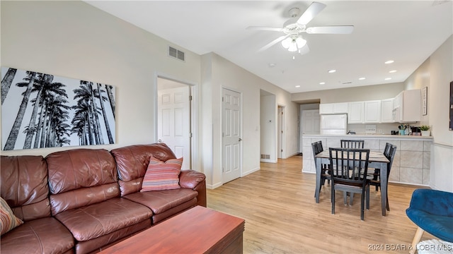 living room with light hardwood / wood-style floors and ceiling fan