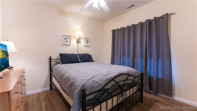 bedroom with ceiling fan and dark hardwood / wood-style flooring