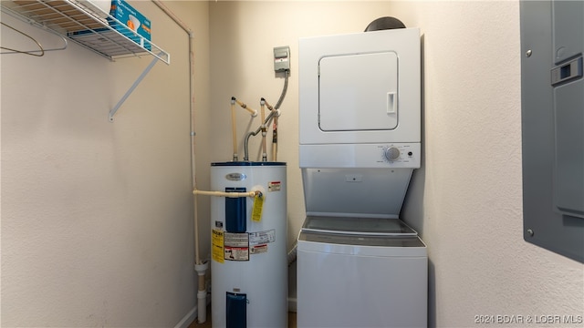 laundry area featuring stacked washer / drying machine and electric water heater