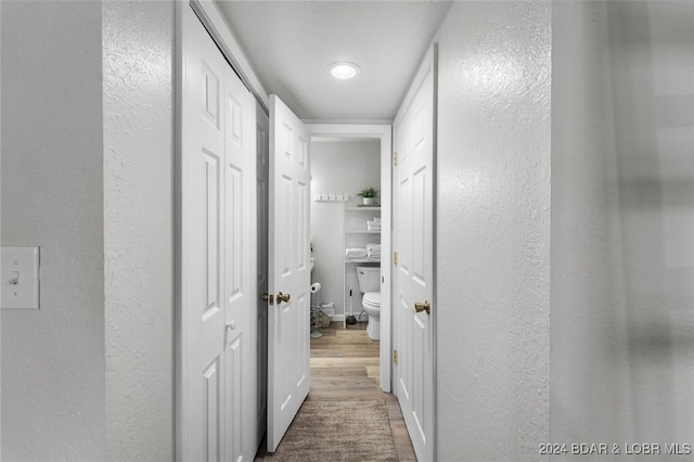 hall featuring recessed lighting, wood finished floors, and a textured wall