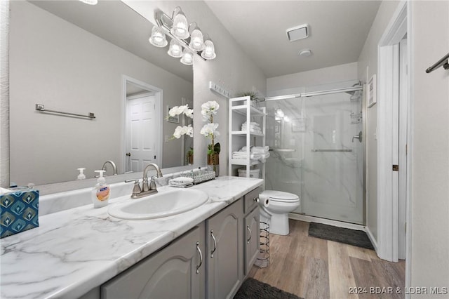 full bathroom featuring visible vents, a marble finish shower, toilet, wood finished floors, and vanity