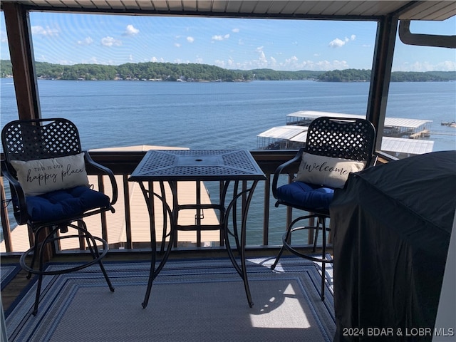 balcony featuring a water view and a grill