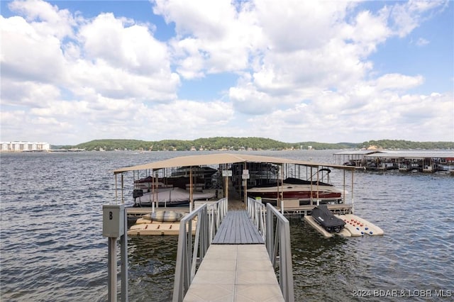 dock area featuring boat lift and a water view