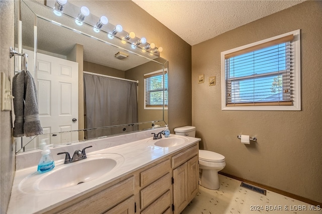 bathroom featuring toilet, a textured ceiling, walk in shower, and vanity