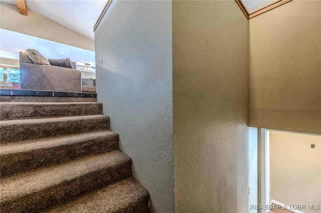 staircase featuring lofted ceiling with beams