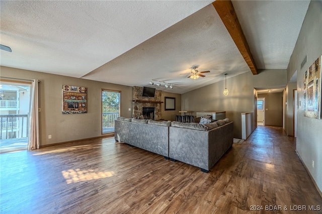 unfurnished living room featuring ceiling fan, a textured ceiling, dark hardwood / wood-style flooring, and vaulted ceiling with beams