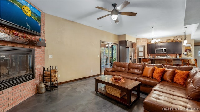 living room with a brick fireplace and ceiling fan with notable chandelier