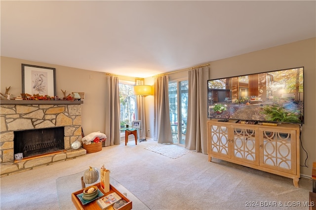 carpeted living room featuring a stone fireplace