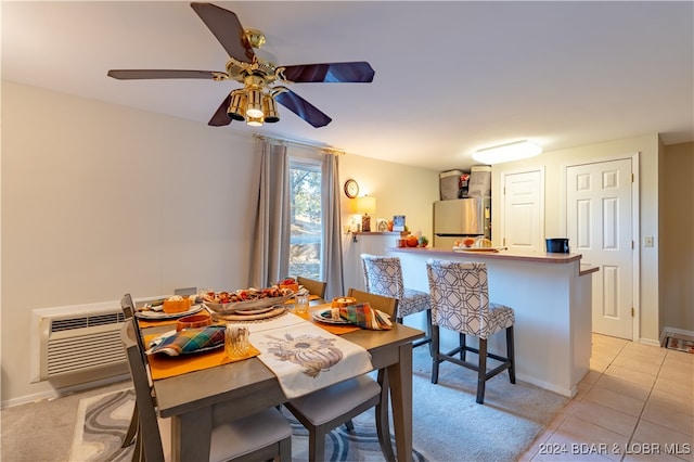 dining space with ceiling fan, an AC wall unit, and light tile patterned floors