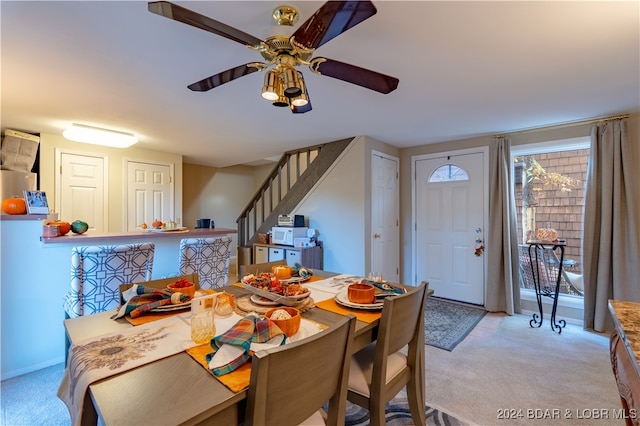 carpeted dining room featuring ceiling fan