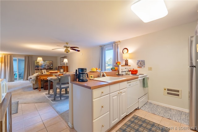 kitchen featuring white cabinets, ceiling fan, light tile patterned floors, white dishwasher, and sink