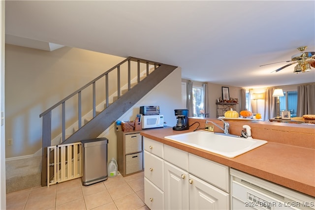 kitchen featuring white appliances, light tile patterned flooring, sink, ceiling fan, and white cabinets