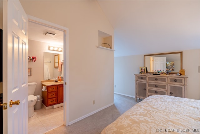 carpeted bedroom featuring lofted ceiling and connected bathroom