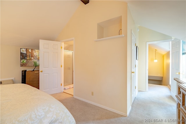 bedroom with lofted ceiling, light colored carpet, and connected bathroom