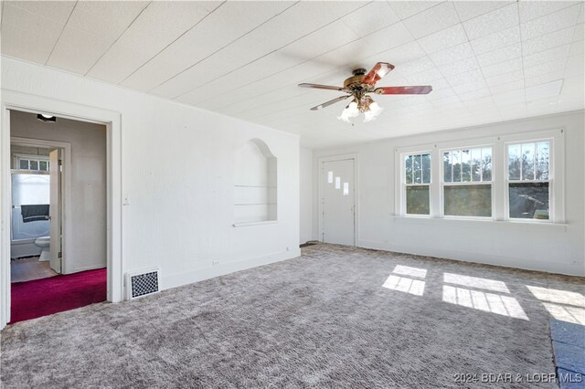 unfurnished living room with carpet flooring and ceiling fan