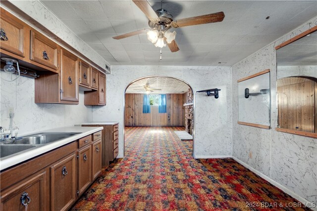 kitchen featuring dark colored carpet, sink, and ceiling fan