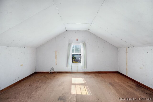 additional living space with lofted ceiling and hardwood / wood-style floors