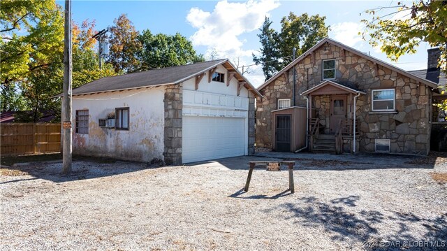 view of front of house with a garage and an outbuilding