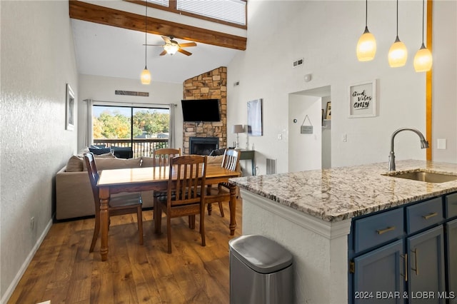 kitchen featuring sink, hanging light fixtures, a fireplace, and dark hardwood / wood-style floors