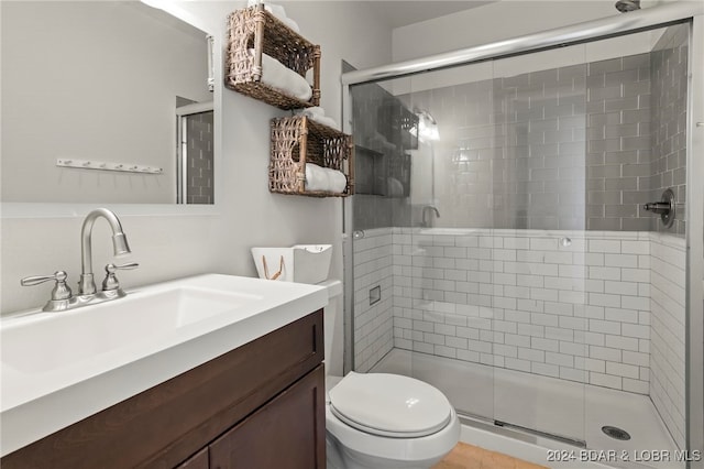 bathroom with vanity, toilet, tile patterned flooring, and a shower with door