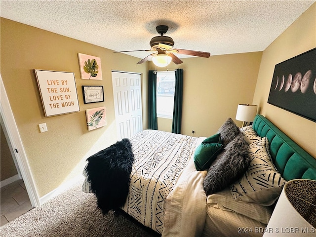 bedroom with tile patterned floors, a textured ceiling, a closet, and ceiling fan