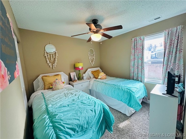 bedroom featuring a textured ceiling, carpet floors, and ceiling fan