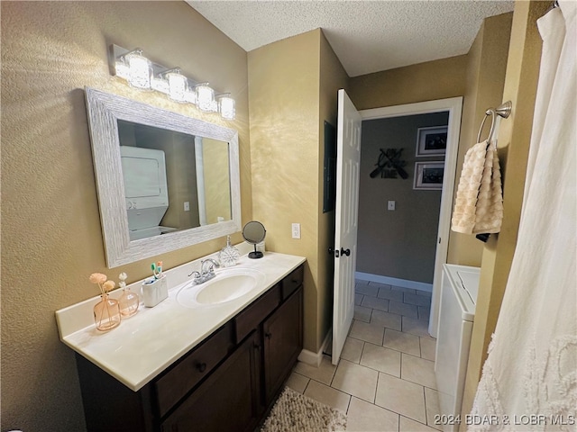 bathroom with vanity, a textured ceiling, stacked washer / dryer, and tile patterned floors