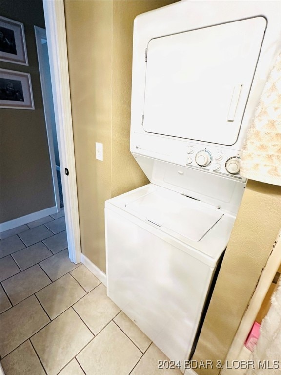 washroom with stacked washer / dryer and light tile patterned floors