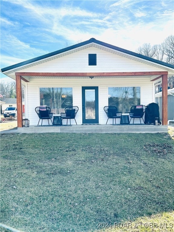 rear view of house featuring a yard and a patio area