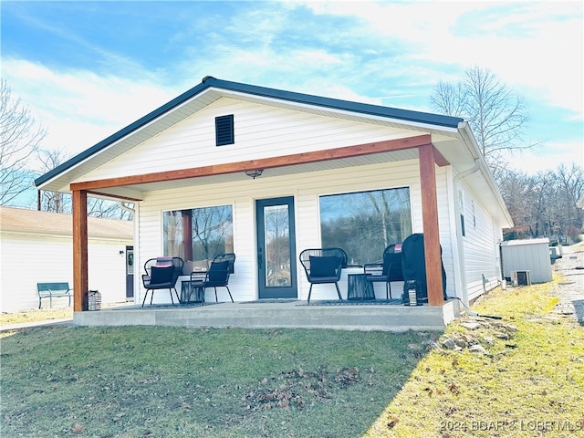 back of property with a yard and a patio