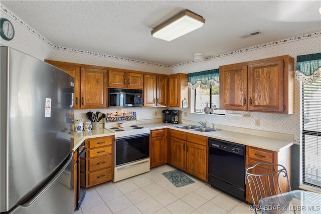 kitchen featuring a textured ceiling, sink, plenty of natural light, and black appliances