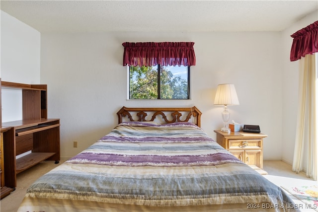 bedroom featuring a textured ceiling and light carpet