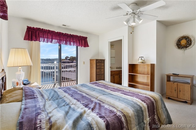 bedroom with ceiling fan, carpet, ensuite bathroom, and a textured ceiling