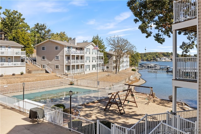 view of pool featuring area for grilling and a water view