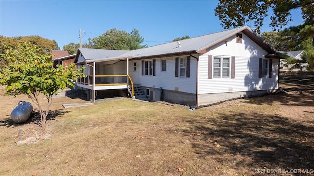 exterior space with a wooden deck, cooling unit, and a front lawn