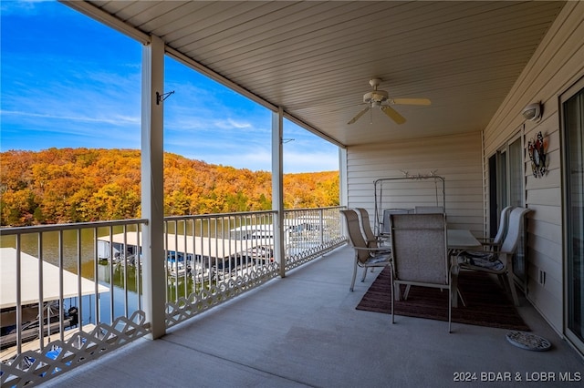 balcony with a water view and ceiling fan