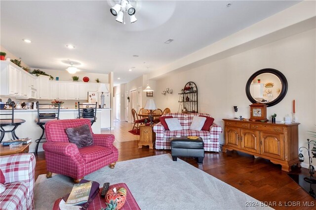 living room with dark hardwood / wood-style floors and ceiling fan