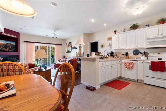 kitchen with kitchen peninsula, white cabinets, ceiling fan, sink, and white appliances