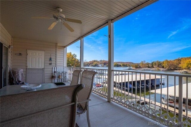 balcony with a water view, ceiling fan, and grilling area