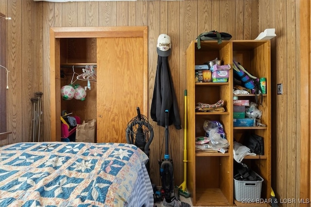 bedroom with a closet and wood walls